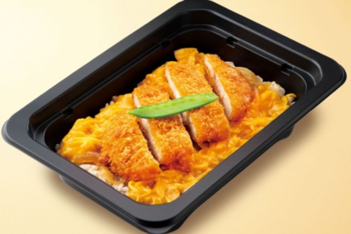 검은색 용기에 담긴 돈가스와 달걀 토핑의 가츠동 냉동제품